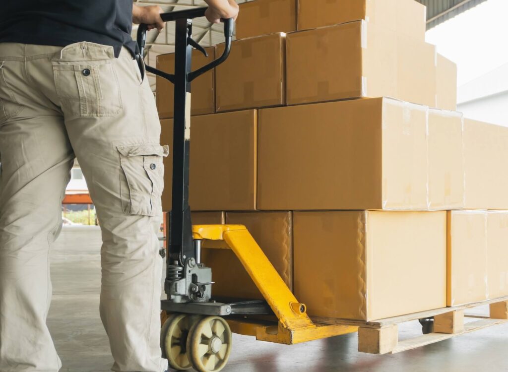 A man hauling boxes for moving overseas by using a dolly