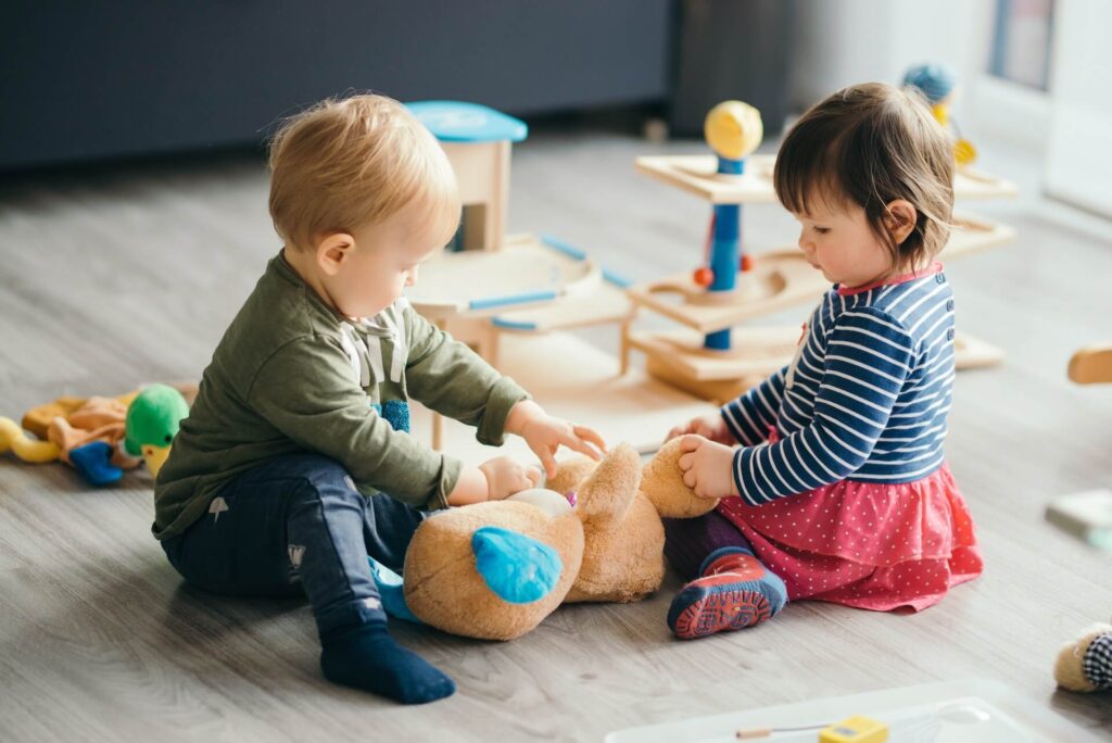 A baby girl and boy playing before moving internationally