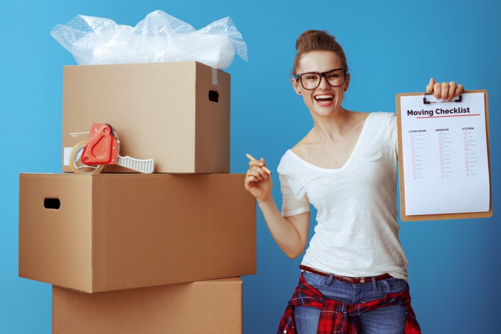 Woman holding a checklist next to boxes prepared for international movers