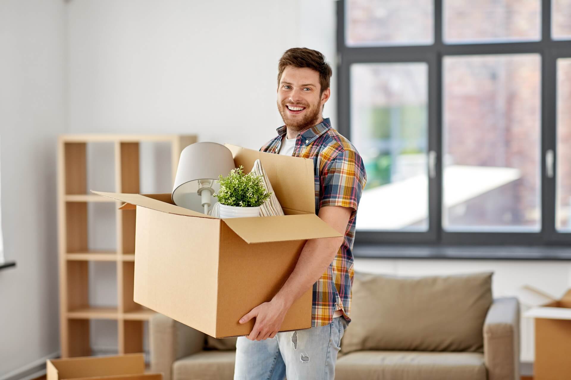 A man smiling and packing for moving overseas