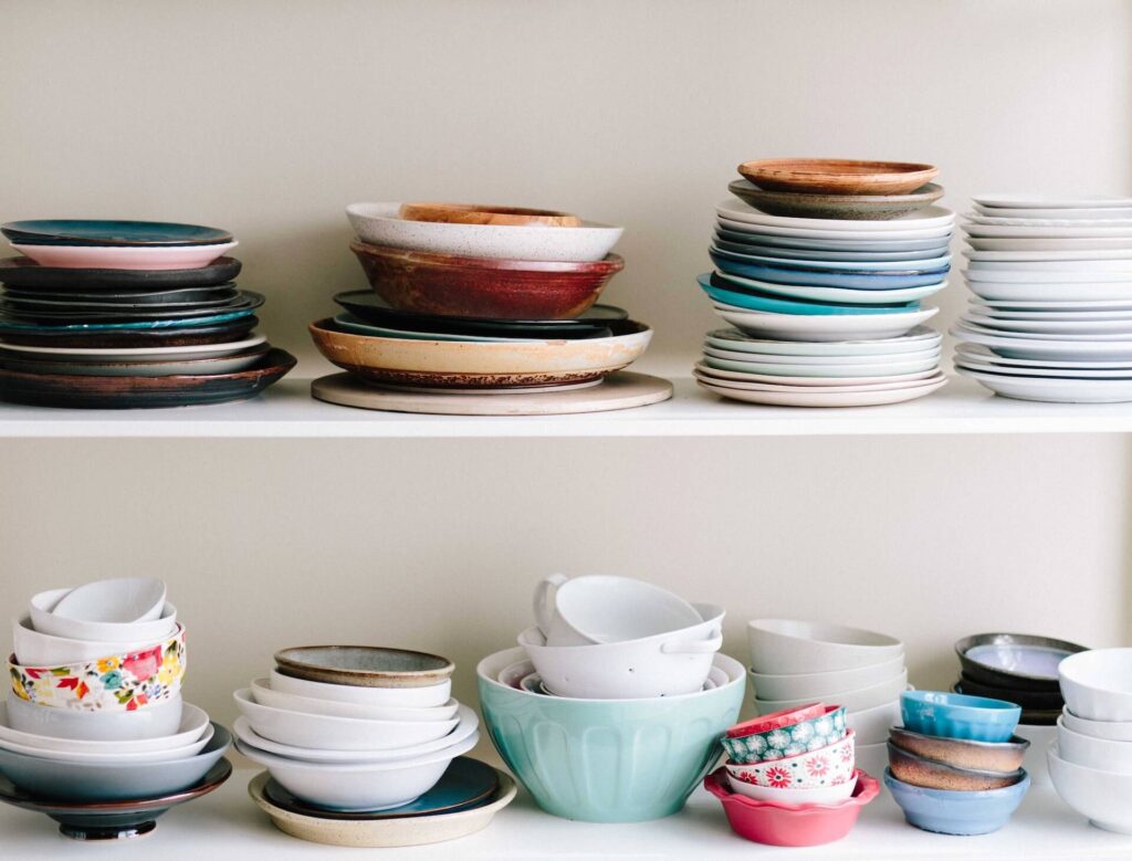 A shelf with many colorful plates in different sizes