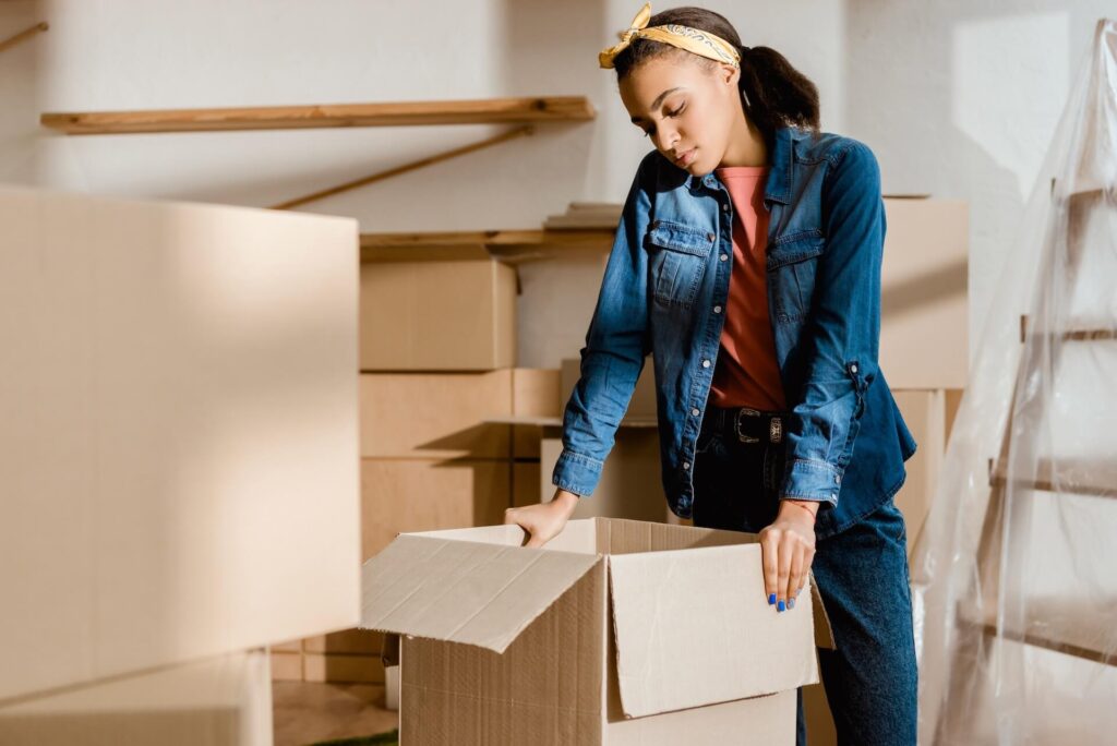 Girl surrounded by boxes before moving internationally