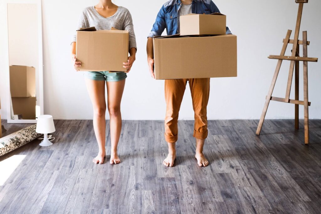 Two people holding boxes and getting ready for the arrival of the international moving company 