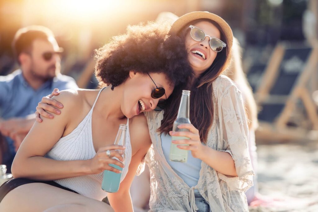 Two women smiling and drinking