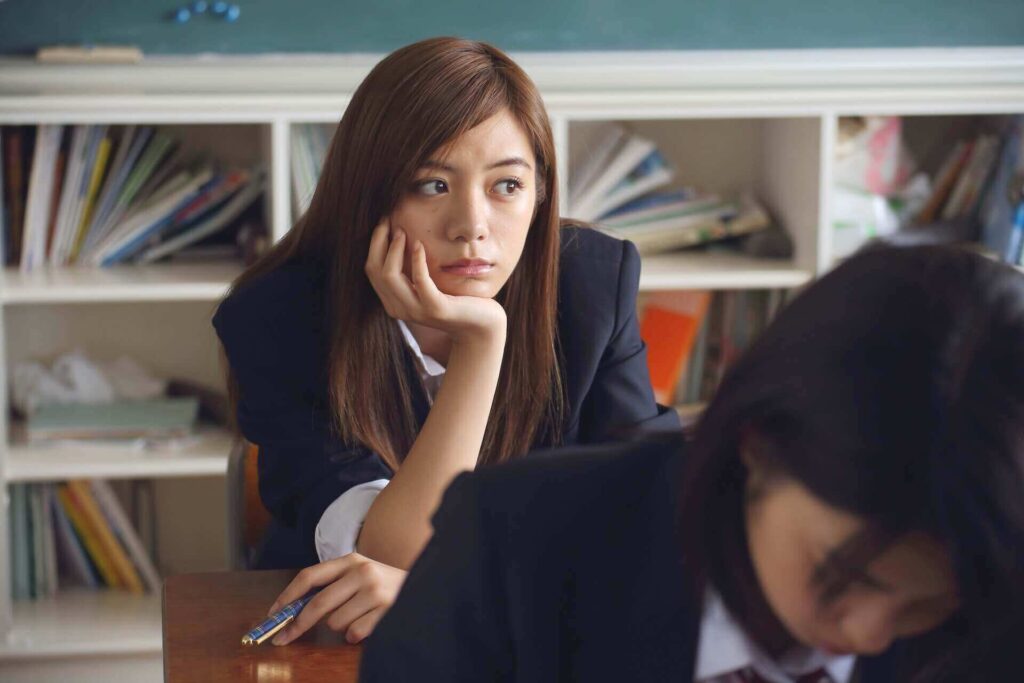 An adolescent girl sitting in a classroom