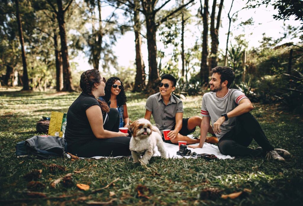 A group of people sitting on a mat in nature