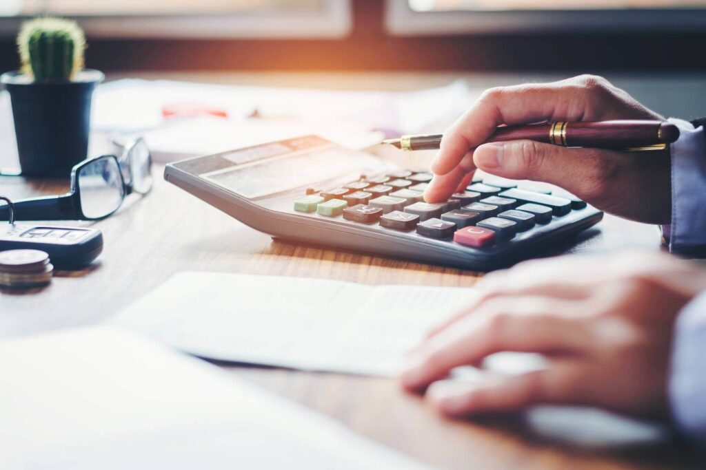 A man using a calculator when figuring out the international moving services costs 