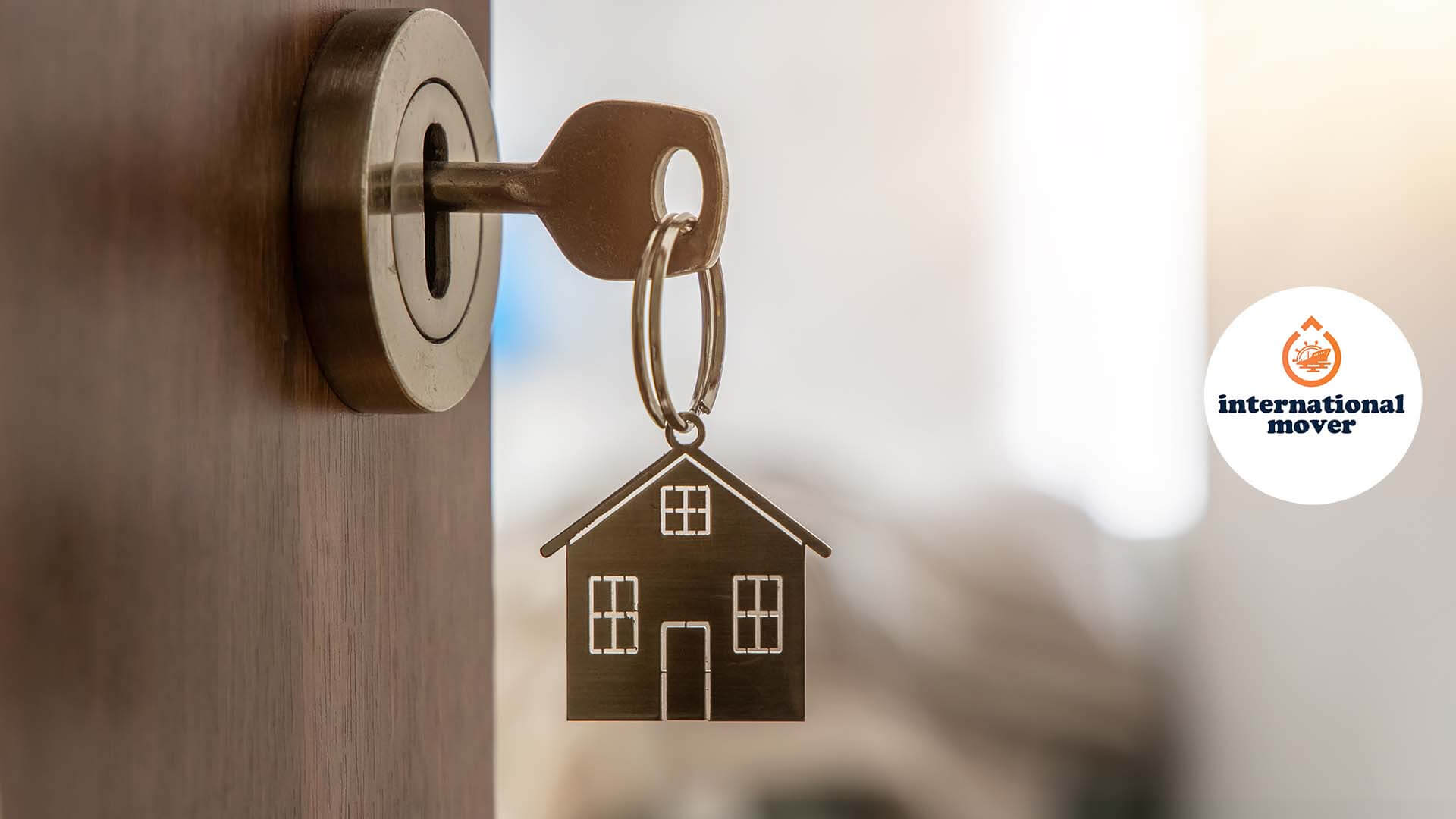 Key in a lock with a keychain in the shape of a house