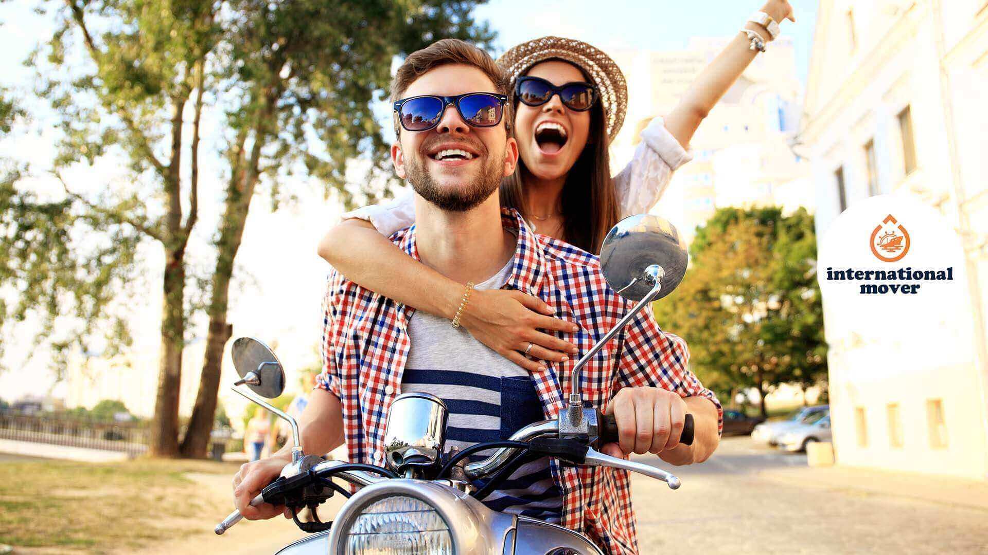 Happy couple on a moped after moving internationally