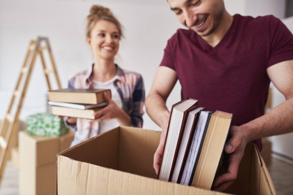 A couple is packing books before moving internationally